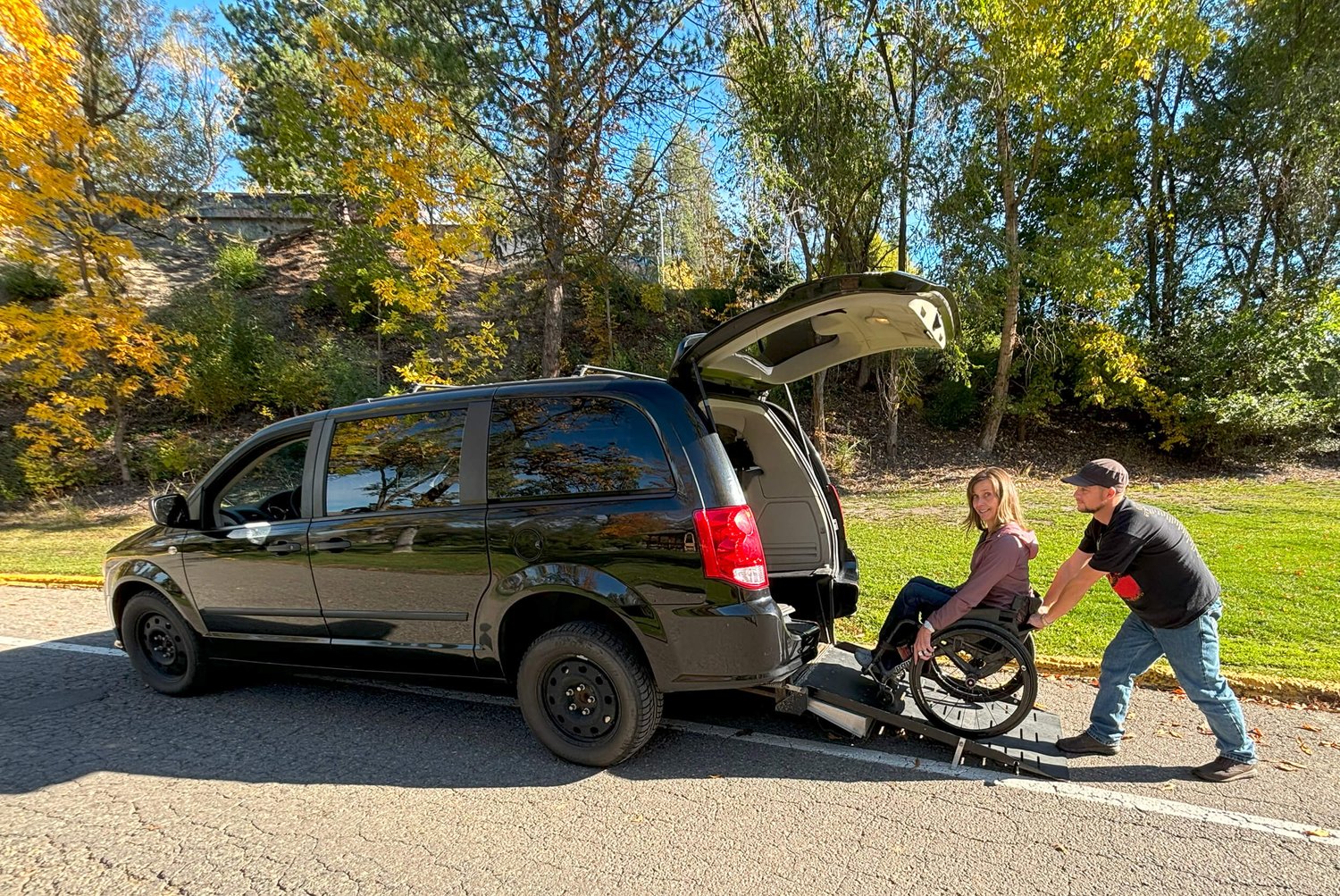 A NOW Shuttle wheelchair accessible van with the rear entry ramp in use.