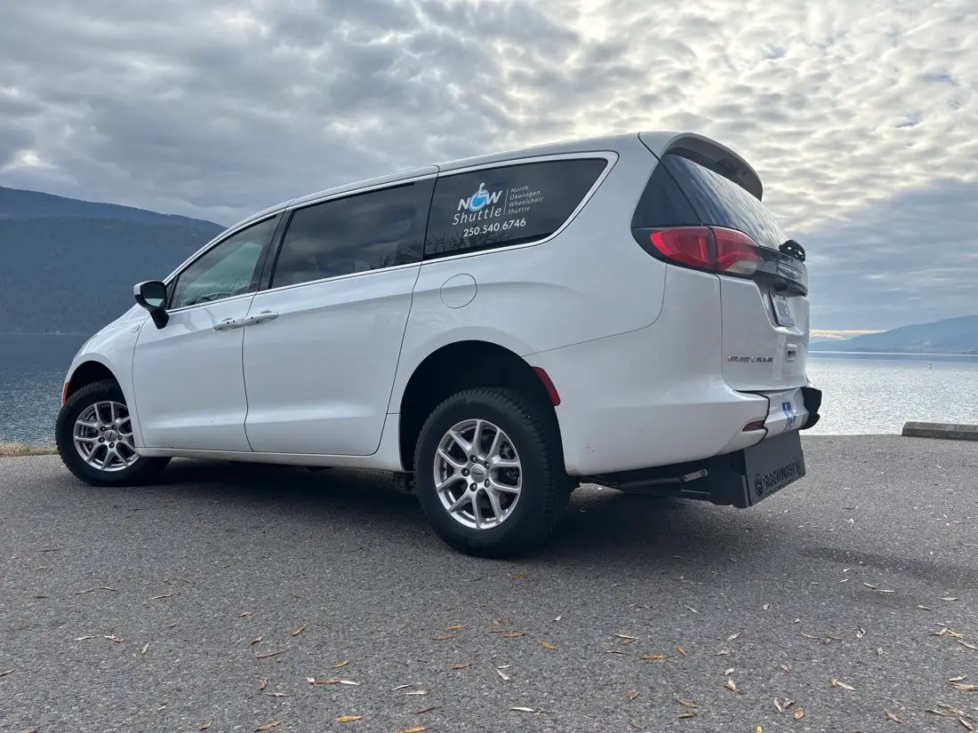 A NOW Shuttle van parked beside Okanagan Lake