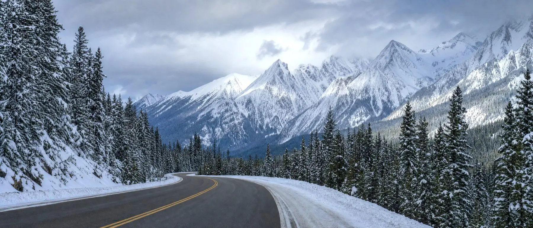 A snow-covered mountain highway winding through the BC Interior in winter